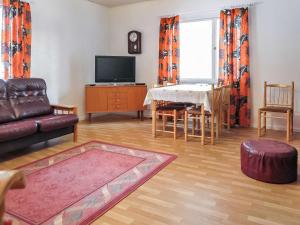 a living room with a couch and a table at Holiday Home Levin mummola by Interhome in Köngäs +13 photos