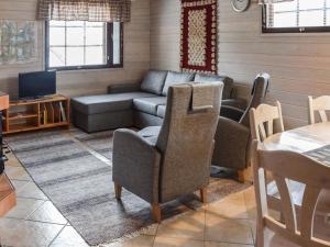 a living room with a couch and a tv at Holiday Home Ahonlaita by Interhome in Karvonen