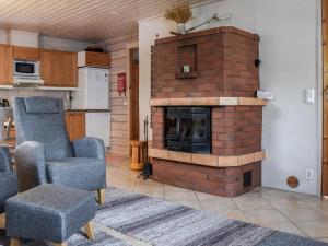 a living room with a brick fireplace and a chair at Holiday Home Ahonlaita by Interhome in Karvonen