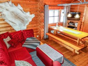 a living room with a red couch and a table at Holiday Home Tikkatupa by Interhome in Levi