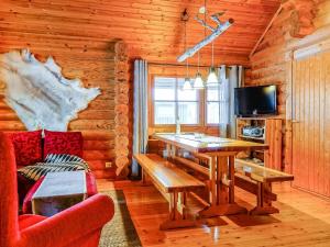 a dining room with a table in a log cabin at Holiday Home Tikkatupa by Interhome in Levi +18 photos