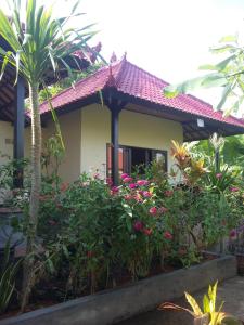 een huis met bloemen en planten ervoor bij Surya Homestay in Selemadeg