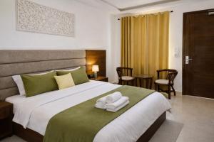 a bedroom with a large bed with two towels on it at Ima Ganga Hotel - Aesthetic, Quite Mountain View Rooms In Upper Tapovan with netflix, free airport pickup for 7 or more nights booking in Rishīkesh