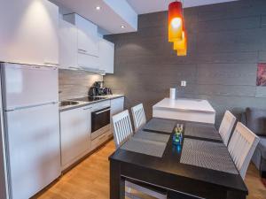 a kitchen with a table with chairs and a refrigerator at Holiday Home Ski chalet 6206 by Interhome in Ylläs