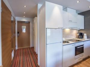 a kitchen with white appliances and a red rug at Holiday Home Ski chalet 6206 by Interhome in Ylläs