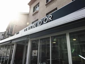 a store with a sign on the front of a building at Hôtel Brasserie Le Lion d'Or in Meximieux