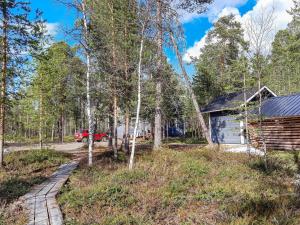 a cabin and a red truck parked in a forest at Holiday Home Hoviranta by Interhome in Veskoniemi