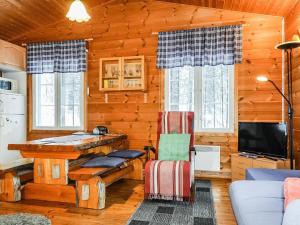 a log cabin living room with a desk and a tv at Holiday Home Hoviranta by Interhome in Veskoniemi +25 photos