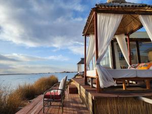 a house on a dock with a bed and chairs at Titicaca island lodge peru in Puno
