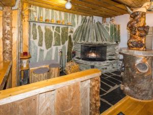 a living room with a fireplace in a log cabin at Holiday Home Örtsylä b by Interhome in Salla