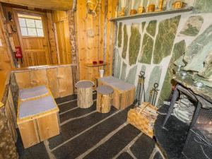 a room in a cabin with benches and a fireplace at Holiday Home Örtsylä b by Interhome in Salla +18 photos