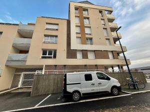 a white van parked in a parking lot in front of a building at Suite Sunset in Saint Malo