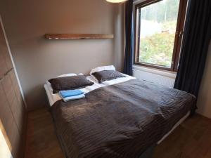 a bedroom with a bed with pillows and a window at Holiday Home Ylläs chalets 3207 by Interhome in Ylläs +5 photos