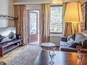 a living room with a couch and a tv at Holiday Home Ylläs chalets 3207 by Interhome in Ylläs