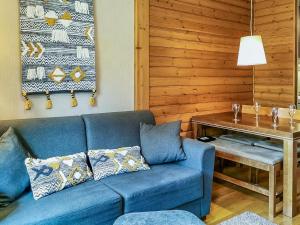 a blue couch in a living room with a table at Holiday Home Ylläs chalets 3207 by Interhome in Ylläs