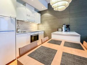 a kitchen with a wooden table and a kitchen with a refrigerator at Holiday Home Ski chalets 6203 by Interhome in Ylläs