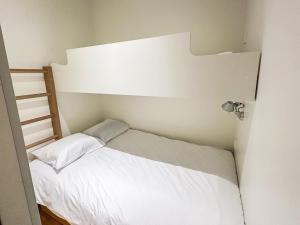 a small bedroom with a white bed and a ladder at Holiday Home Ski chalets 6203 by Interhome in Ylläs +6 photos