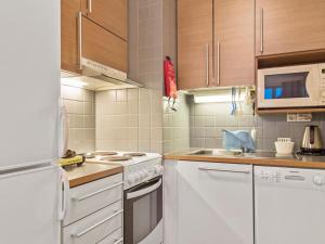 a kitchen with white appliances and wooden cabinets at Holiday Home Ylläs chalets a502 by Interhome in Ylläs