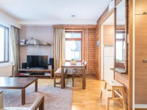 a living room with a table and a television at Holiday Home Ylläs chalets 3210 by Interhome in Ylläs +10 photos