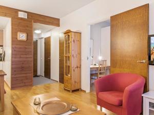a living room with a red chair and a table at Holiday Home Ylläs chalets a502 by Interhome in Ylläs +7 photos