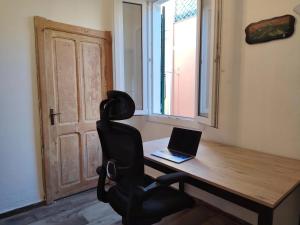 an office with a desk with a laptop and a chair at Da Marilena in Sorso