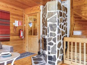 a room with a stone fireplace in a log cabin at Holiday Home Sallanrinne b by Interhome in Salla