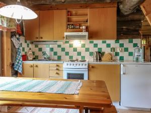 a kitchen with a table and a stove and a refrigerator at Holiday Home Kulpakko 2 by Interhome in Tiainen +16 photos