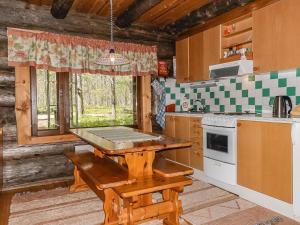 a kitchen with a wooden table in a cabin at Holiday Home Kulpakko 2 by Interhome in Tiainen