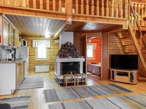 a living room with a fireplace in a log cabin at Holiday Home Piilola by Interhome in Raanujärvi