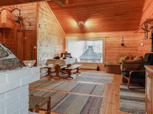 a living room with wooden walls and a large window at Holiday Home Piilola by Interhome in Raanujärvi