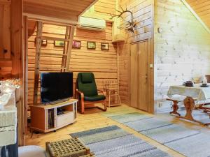 a living room with a television and a green chair at Holiday Home Piilola by Interhome in Raanujärvi