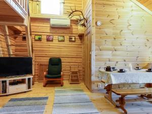 a living room with wooden walls and a television at Holiday Home Piilola by Interhome in Raanujärvi +17 photos