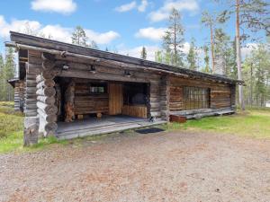 a log cabin with a porch in a field at Holiday Home Metsä-luosto by Interhome in Luosto