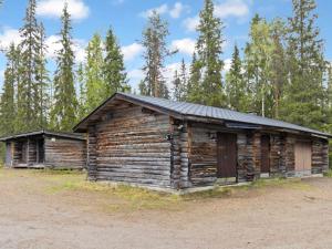 an old log cabin with a black roof at Holiday Home Metsä-luosto by Interhome in Luosto