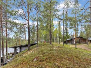 a cabin in the woods next to a lake at Holiday Home Metsä-luosto by Interhome in Luosto