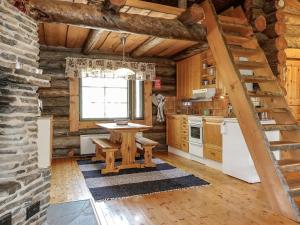 a kitchen with a table in a log cabin at Holiday Home Kulpakko 3 by Interhome in Tiainen