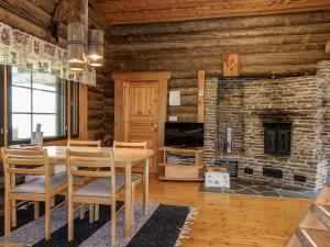 a dining room with a table and a stone fireplace at Holiday Home Kulpakko 3 by Interhome in Tiainen +16 photos