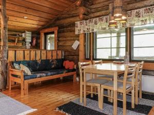 a dining room with a table and a couch at Holiday Home Kulpakko 3 by Interhome in Tiainen