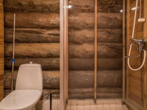 a bathroom with a toilet and a wooden wall at Holiday Home Ylläsparit as- 2 by Interhome in Ylläsjärvi +8 photos