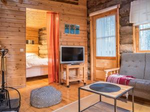 a living room with a tv in a log cabin at Holiday Home Ylläsparit as- 2 by Interhome in Ylläsjärvi