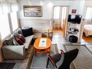 a living room with a couch and a table at Holiday Home Lustola b by Interhome in Luosto