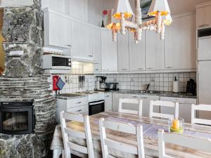 a kitchen with a table and chairs and a fireplace at Holiday Home Lustola b by Interhome in Luosto