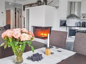 a vase of roses on a table with a fireplace at Holiday Home Villa ylläs 203 by Interhome in Ylläs