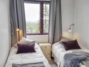 two beds in a room with a window at Holiday Home Villa ylläs 203 by Interhome in Ylläs +14 photos