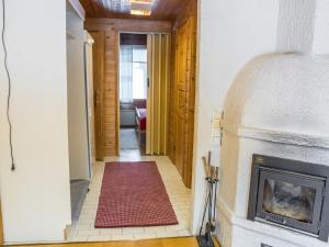 a hallway with a fireplace and a red rug at Holiday Home Tunturinvieri l3 by Interhome in Ylläsjärvi +9 photos