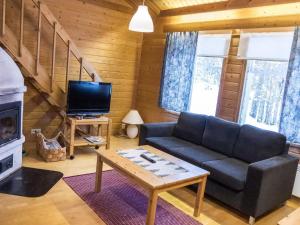 a living room with a couch and a fireplace at Holiday Home Tunturinvieri l3 by Interhome in Ylläsjärvi