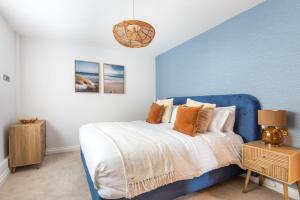 a blue and white bedroom with a bed and a table at Thurlestone Retreats in Thurlestone +35 photos