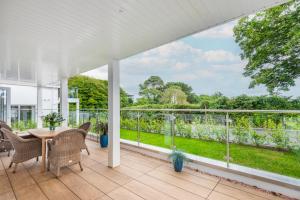 a patio with a table and chairs on a balcony at Thurlestone Retreats in Thurlestone