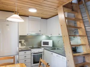 a kitchen with white cabinets and a ladder at Holiday Home Isonparit b3 by Interhome in Ylläsjärvi