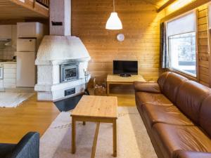 a living room with a couch and a stove at Holiday Home Tunturinvieri k2 by Interhome in Ylläsjärvi